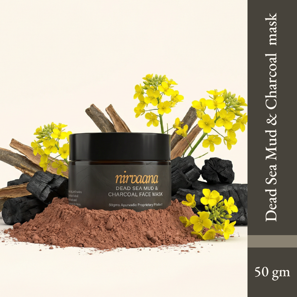Dead Sea Mud and Charcoal Face Mask in a black jar surrounded by charcoal pieces and yellow flowers on a beige background.